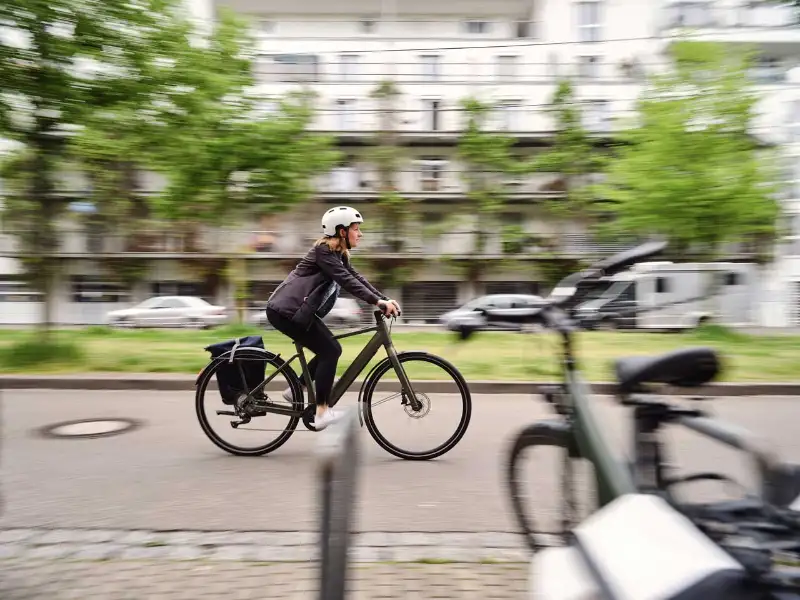 JobRadlerin fährt am Fahrradständer vorbei