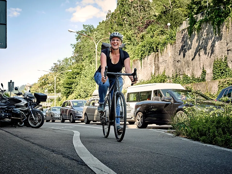 Frau fährt mit JobRad am Stau vorbei Frau fährt mit JobRad am Stau vorbei