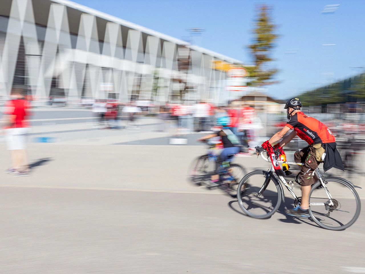 SC Fans in Trikots und Schal fahren mit dem Rad zum Europa-Park Stadion, mit Bewegungsunschärfe SC Fans in Trikots und Schal fahren mit dem Rad zum Europa-Park Stadion, mit Bewegungsunschärfe