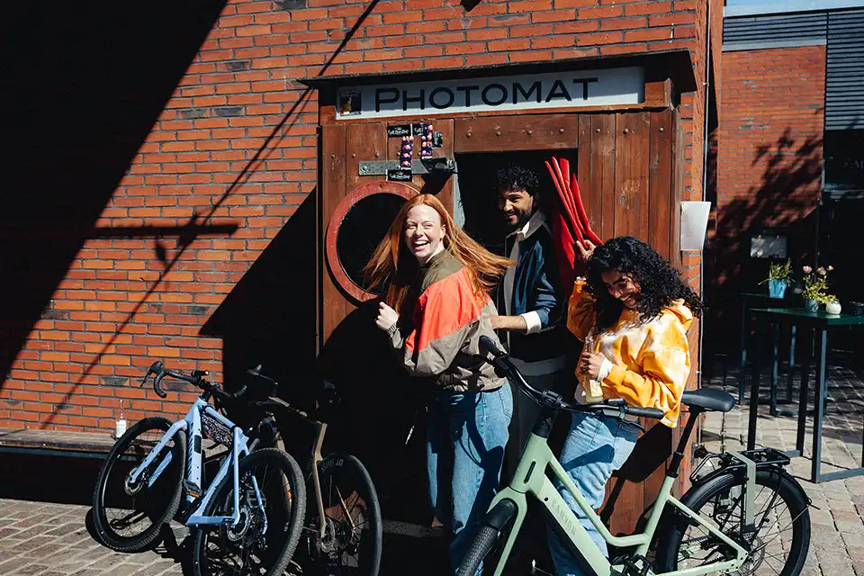 Junge Menschen vor einer Photobox mit Leasing Fahrädern